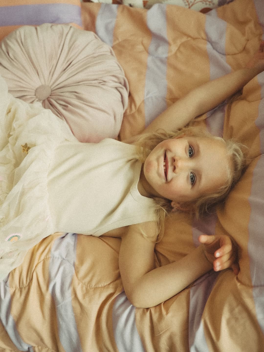 Meisje lacht op een gestreept bed