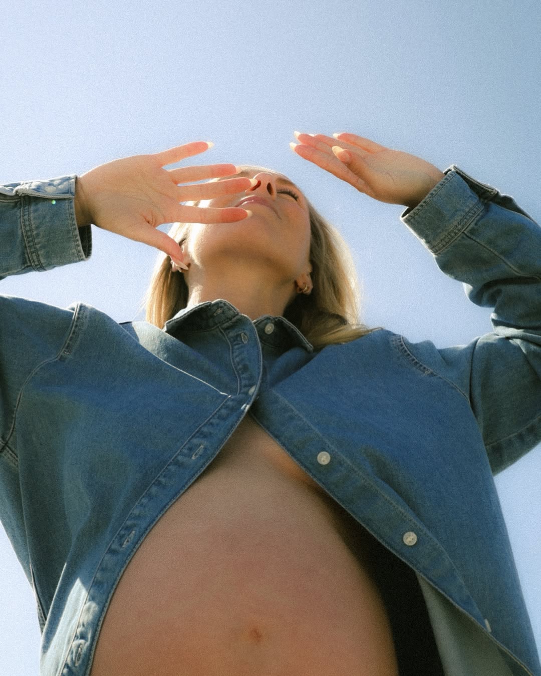 Zwangere vrouw met haar handen in de lucht