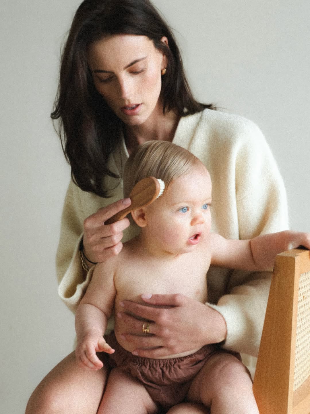 Moeder kamt het haar van haar baby