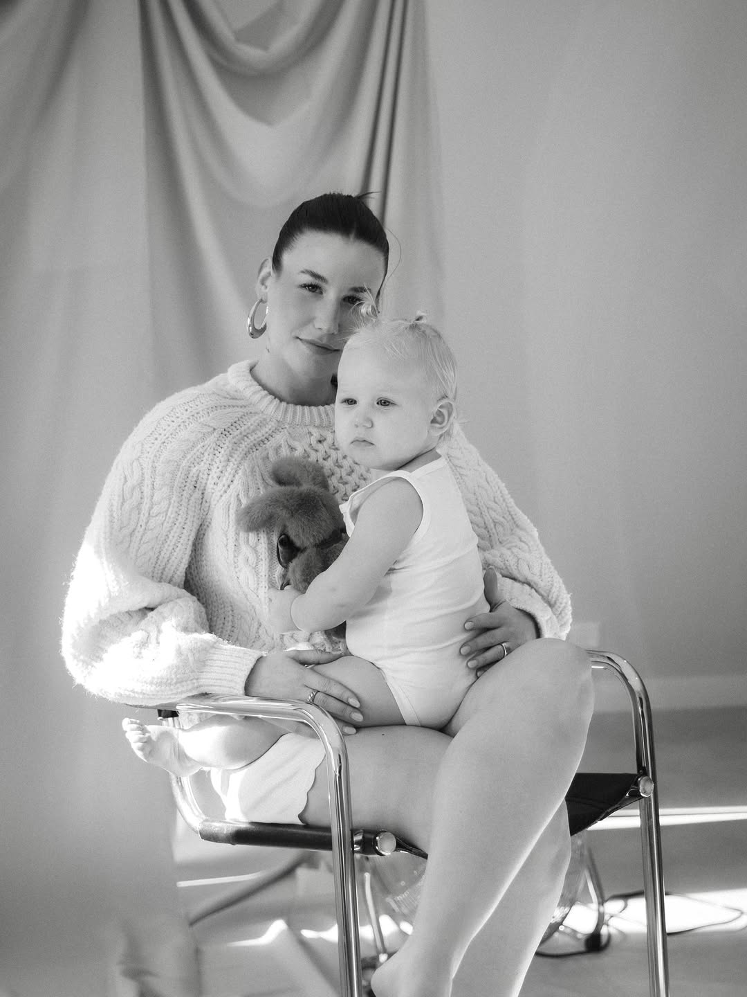 Moeder met baby op een stoel in de studio, zwart-wit