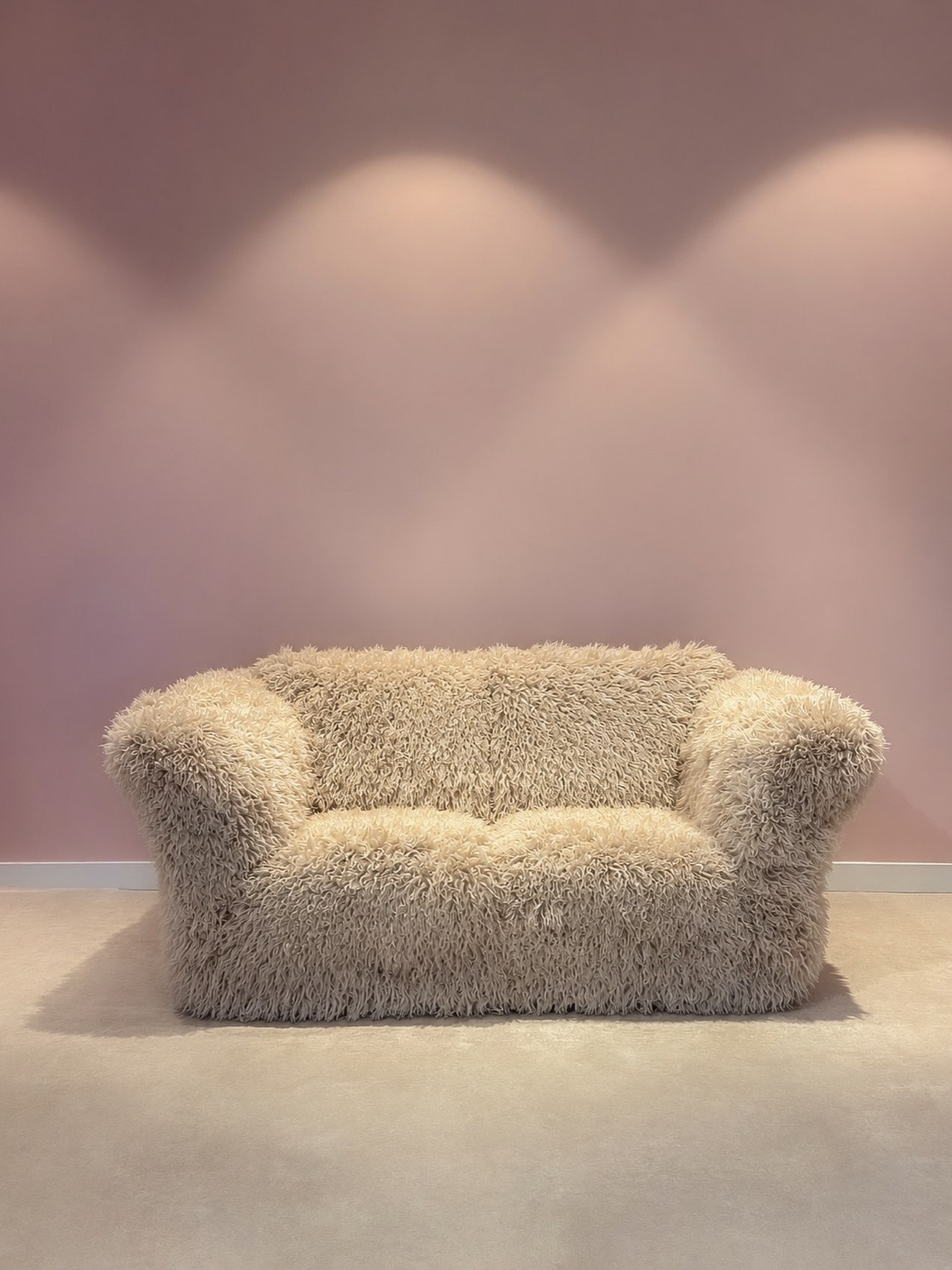 De witte fluffy bank voor een lila muur