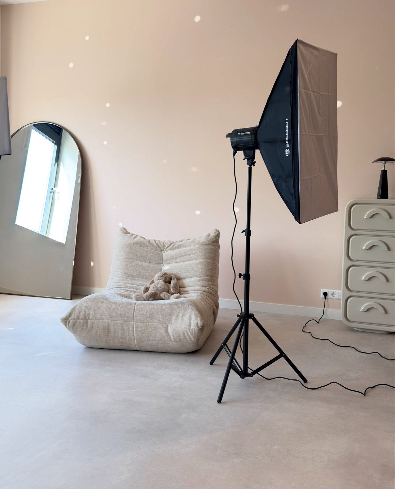 De studio met een togo-fauteuil, een studiolamp en roze muren