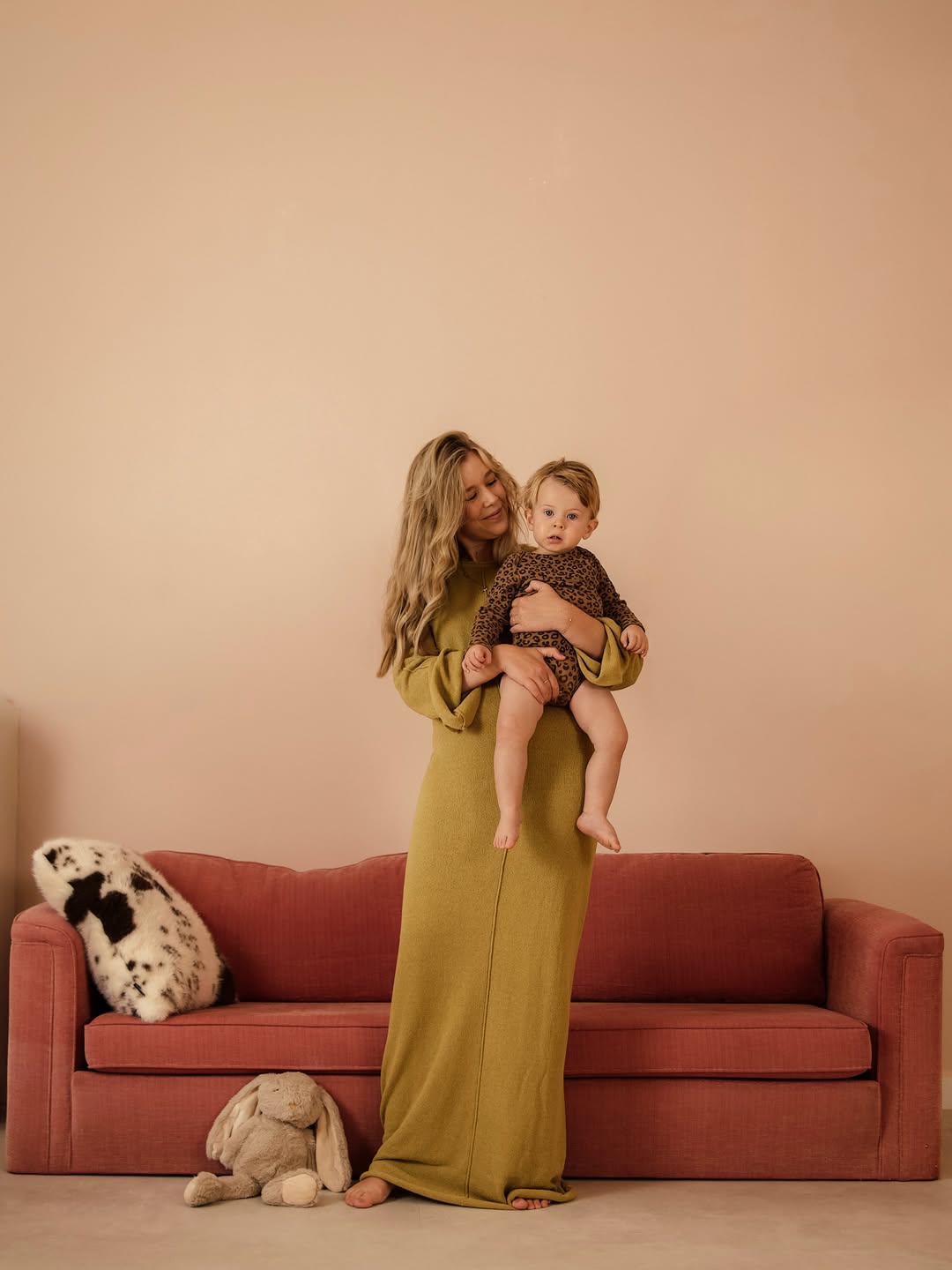 Moeder met baby naast de roze bank in de studio