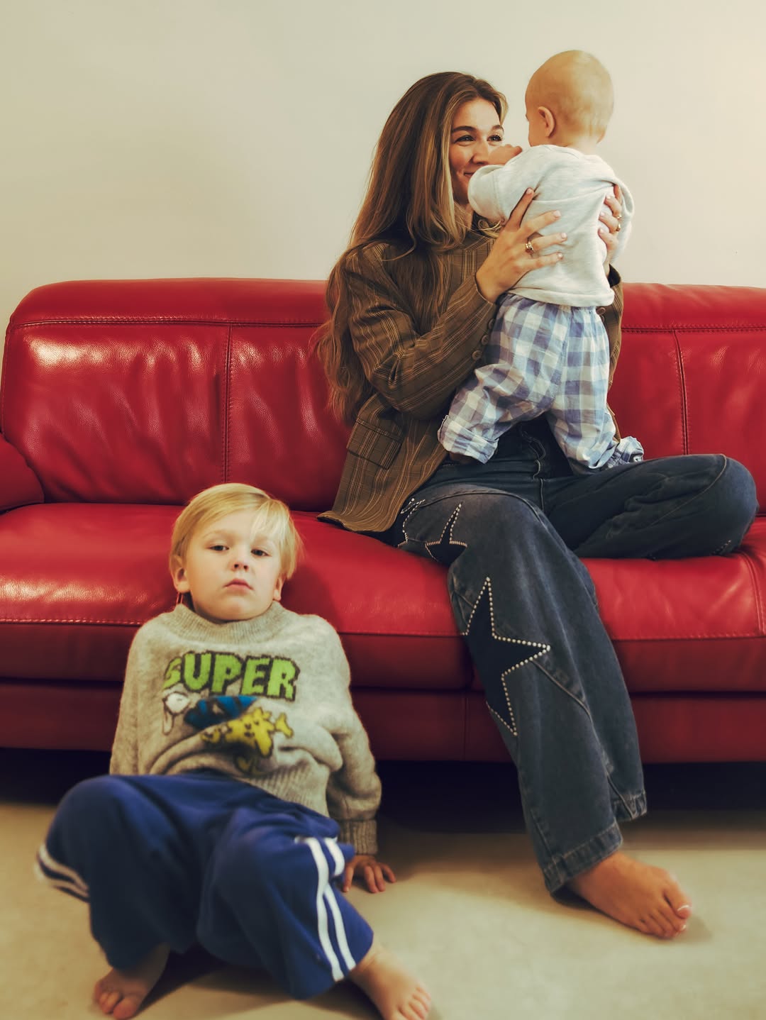 Moeder met kinderen op de rode bank in Studio by Nomi